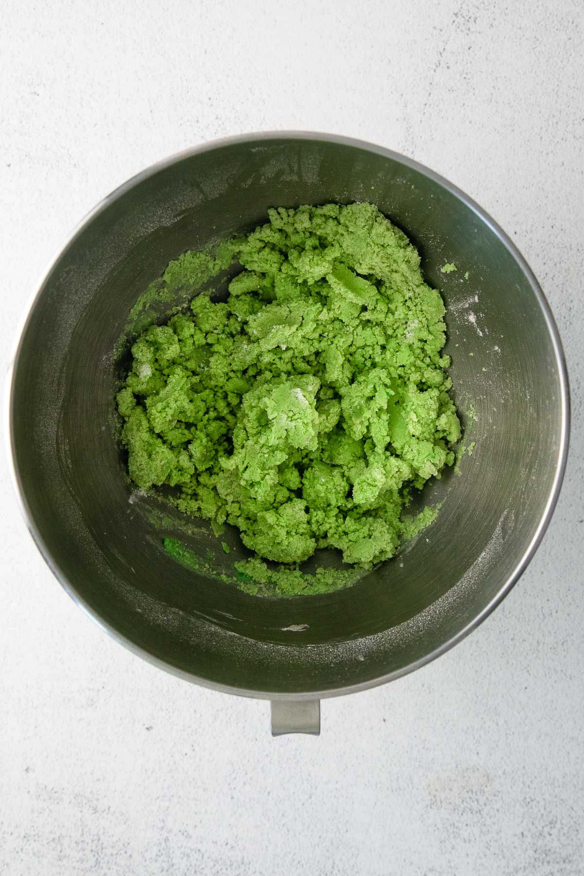 green cookie dough in a stainless steel mixing bowl