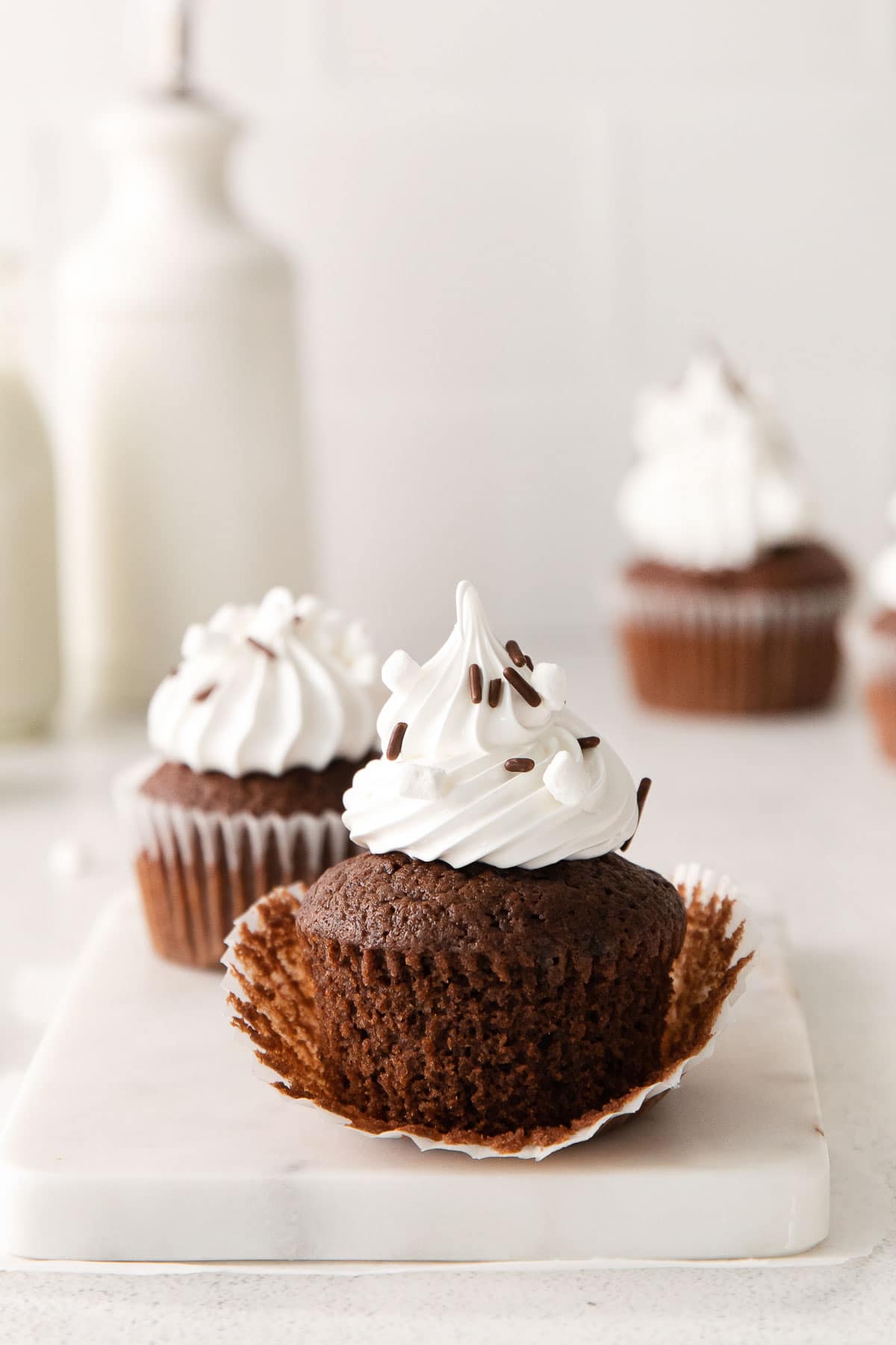 chocolate cupcake topped with white marshmallow frosting with the liner peeled off