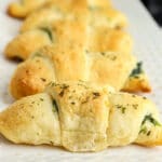 golden brown crescent roll topped with dried parsley