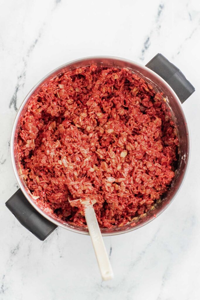 red rice krispie treat mixture in a big silver pot