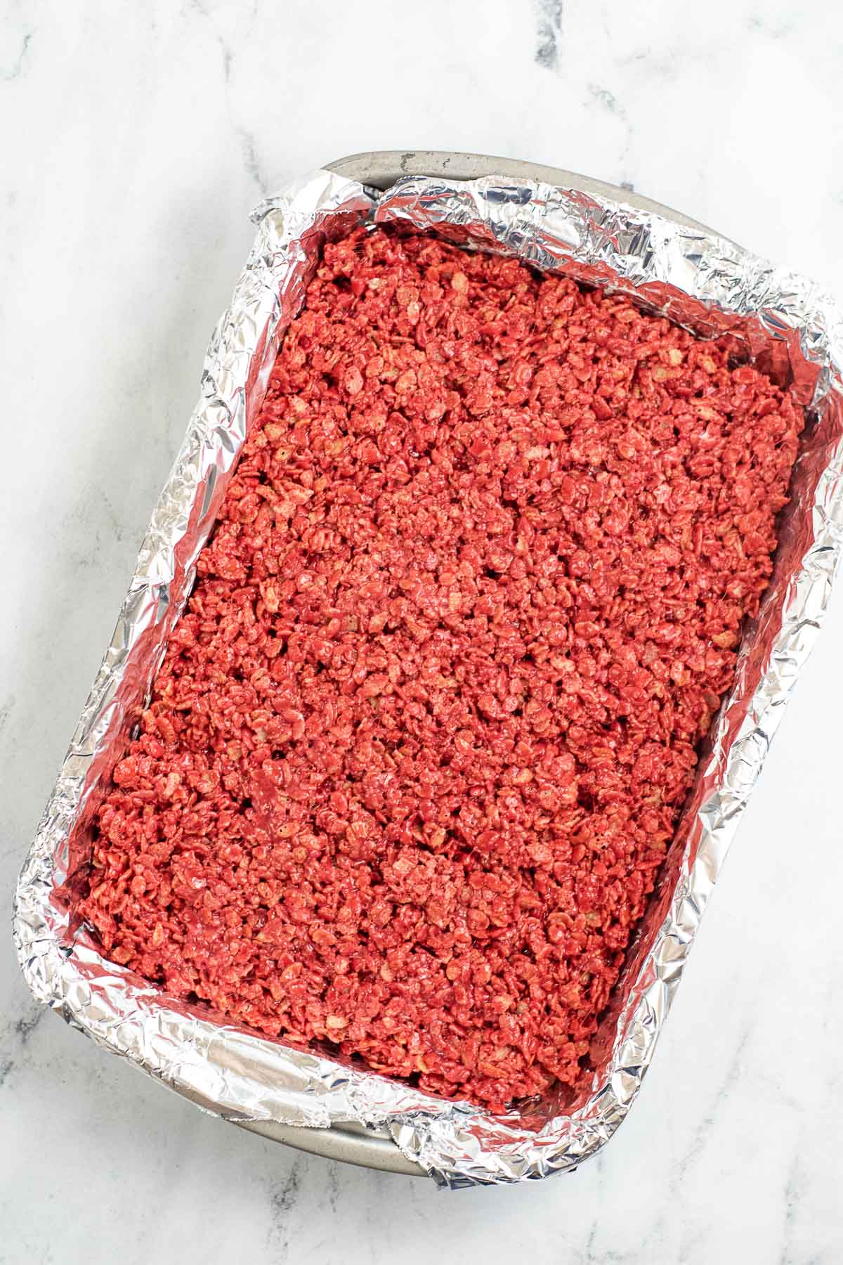 red rice krispie treat mixture pressed in a 9x13 pan