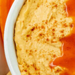 closeup of a white bowl with buffalo hummus