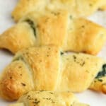 several crescent rolls filled with spinach mixture with on a white plate