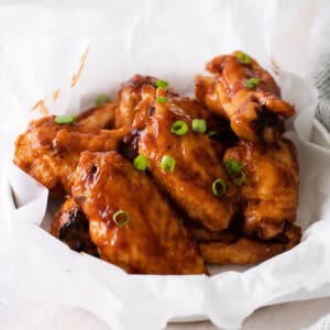 white bowl with chicken wings baked with bbq sauce