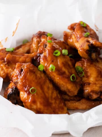 white bowl with chicken wings baked with bbq sauce