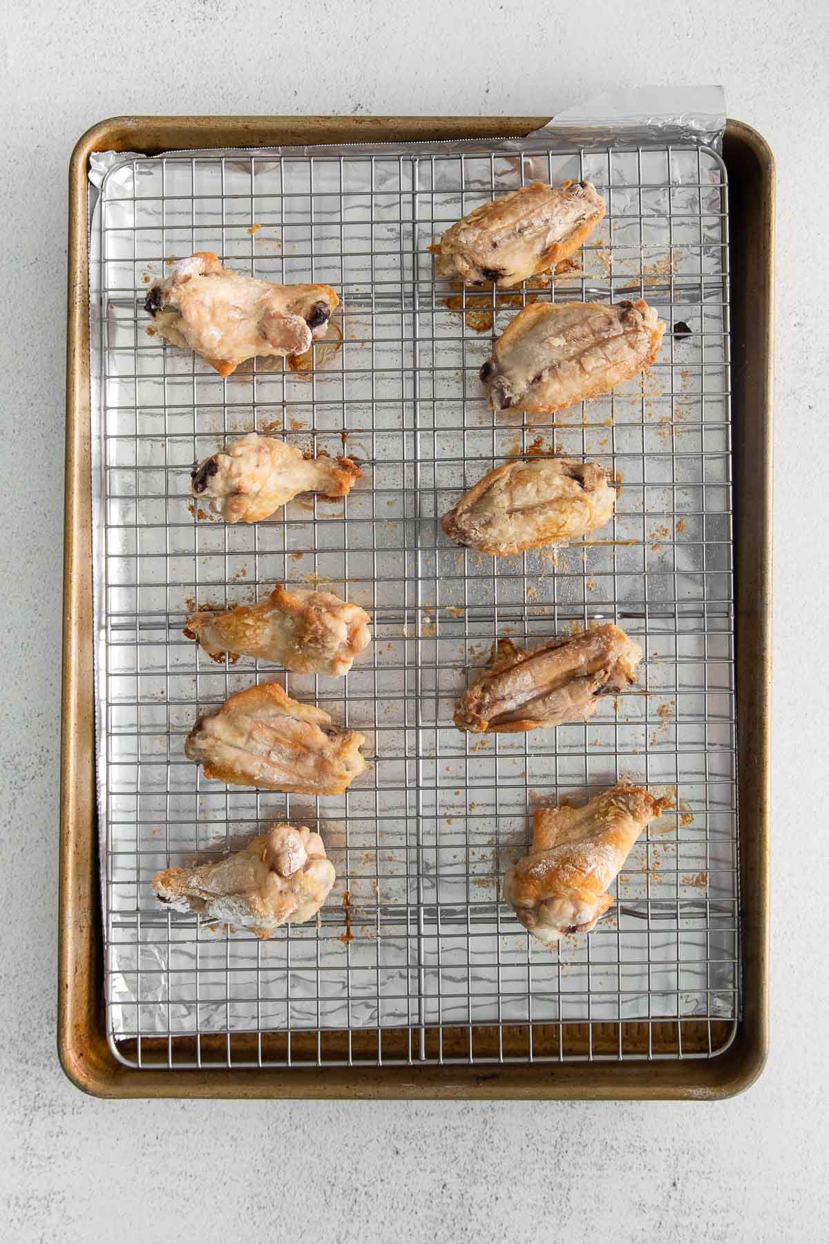 ten chicken wings on a wire rack on a baking sheet