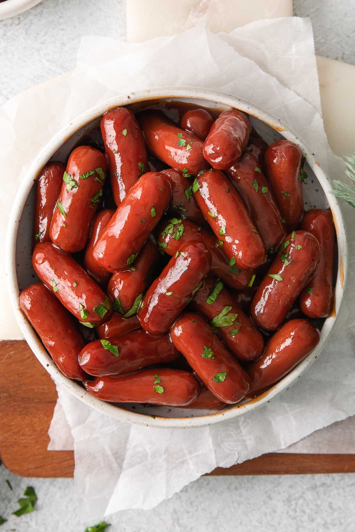 closeup of a bowl full of little smokies hot dogs in a barbecue sauce