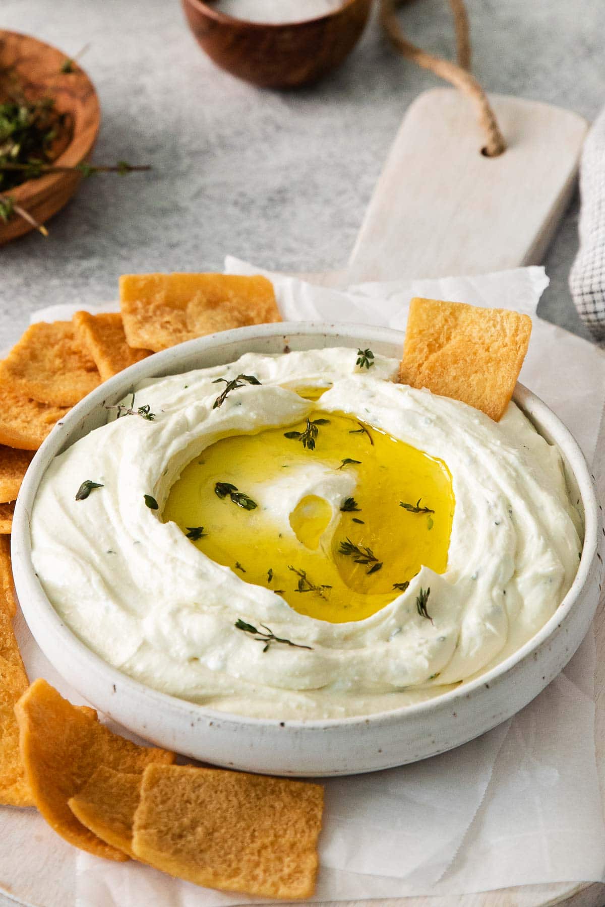 bowl full of whipped feta dip with pita chips surrounding the bowl