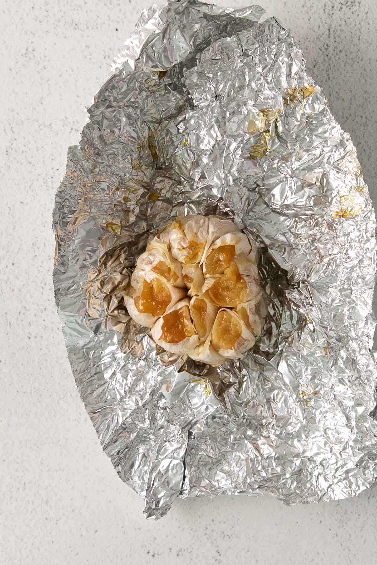 whole roasted garlic clove on aluminum foil