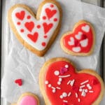 four heart shaped cookies with red and pink icing