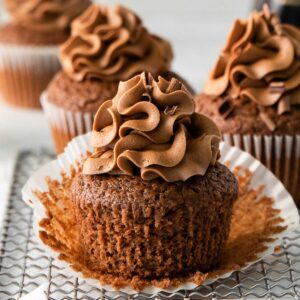 closeup of guinness chocolate cupcake with chocolate frosting with the liner pulled down