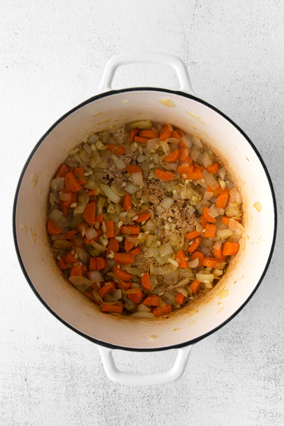 diced carrots, celery and onions sautéing in a white pot