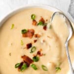 white bowl full of cheese soup topped with bacon and scallions with text ovelay reading Easy Beer Cheese Soup