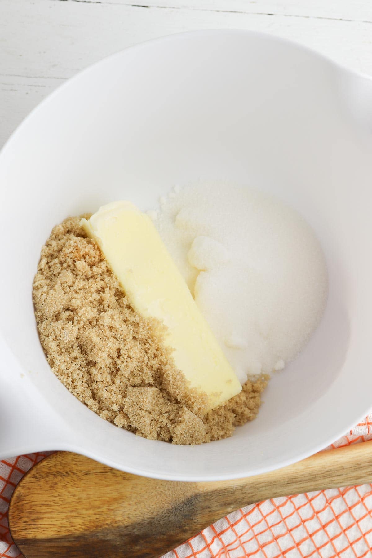 white mixing bowl with brown sugar, white sugar and butter