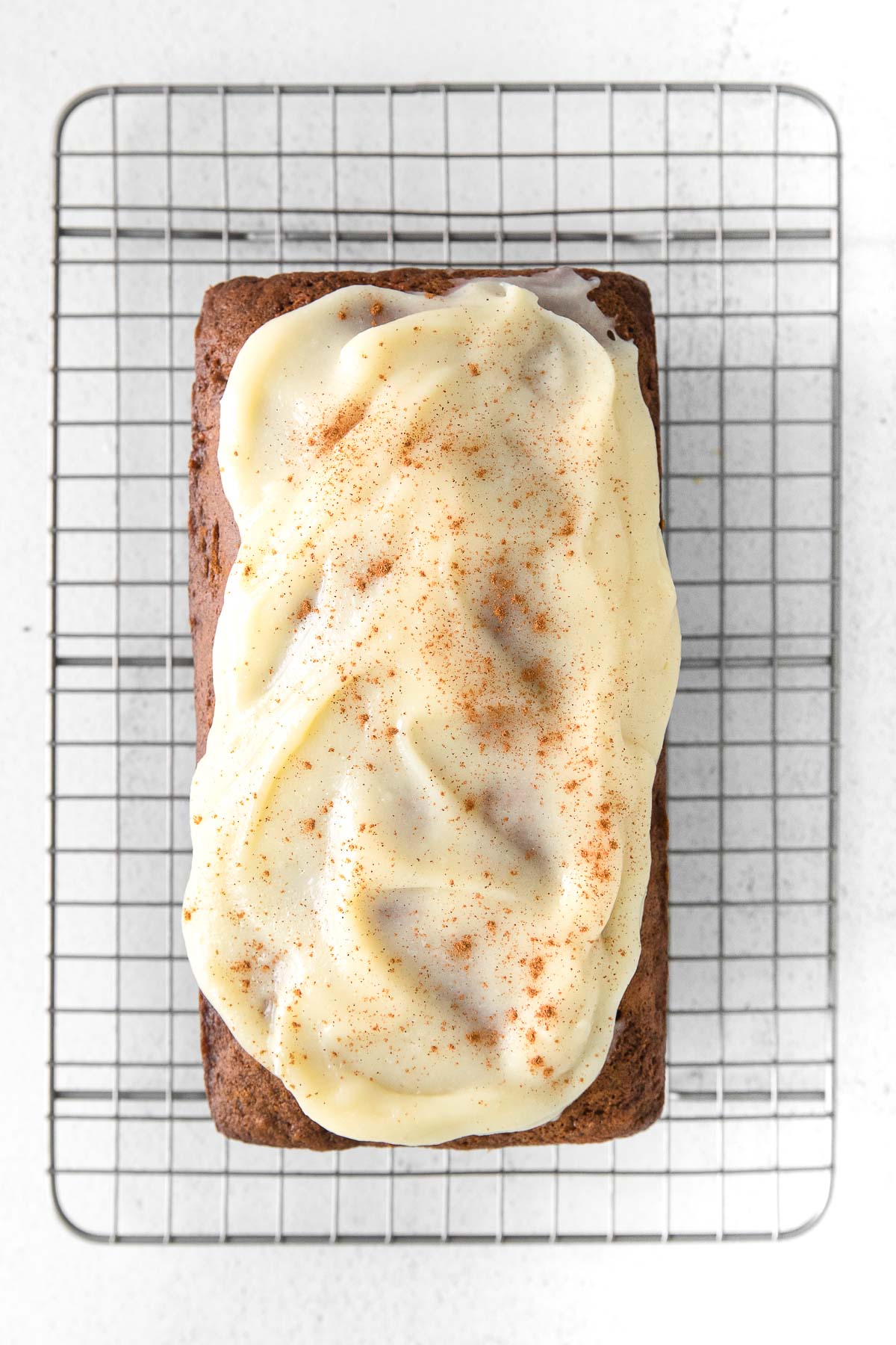 carrot cake loaf with cream cheese frosting on a wire cooling rack