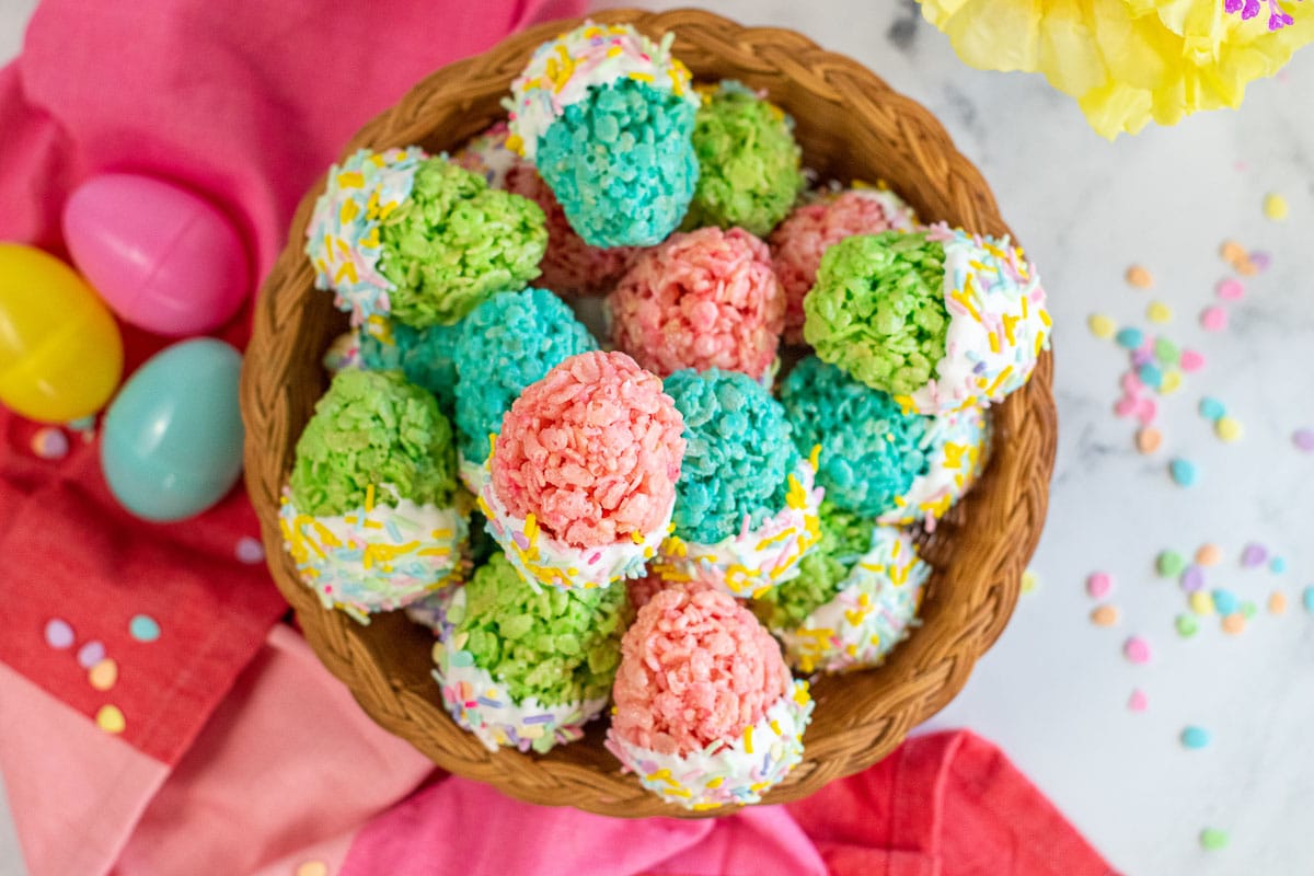 a basket full of blue, pink and green easter egg rice krispie treats