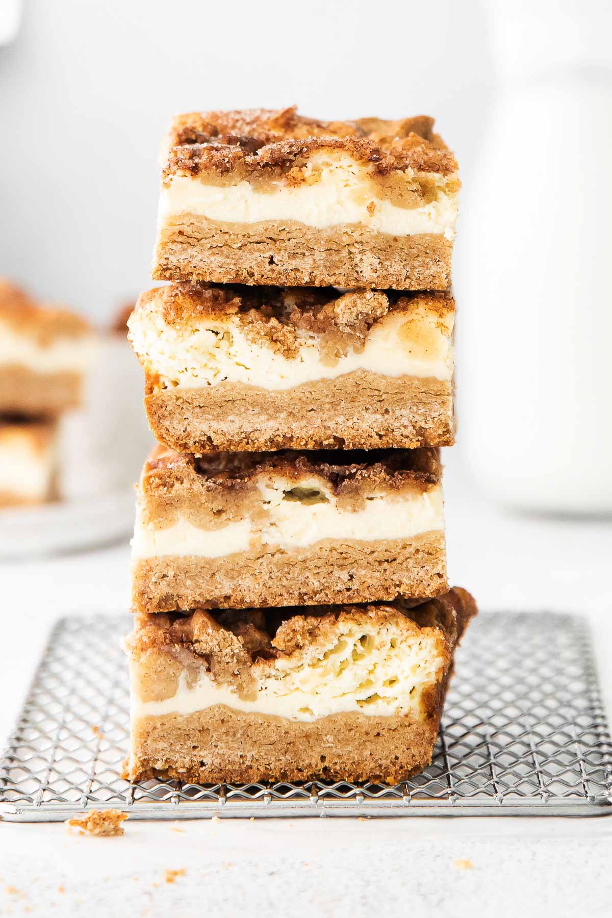 four cheesecake bars stacked on top of each on a wire rack
