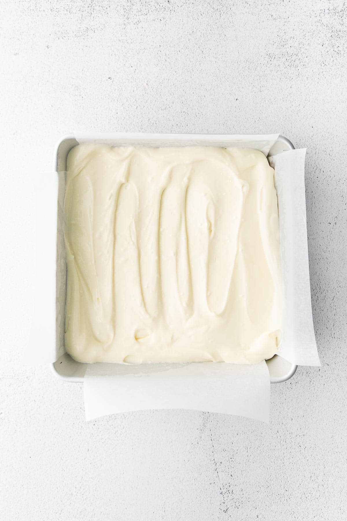 cream cheese mixture spread in a square baking dish