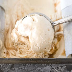 scoop of butterbeer ice cream with vanilla and butterscotch swirls being scooped with a ice cream scooper