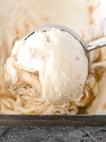 scoop of butterbeer ice cream with vanilla and butterscotch swirls being scooped with a ice cream scooper