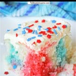 closeup of a slice of red white and blue jello poke cake with with red and blue star sprinkles