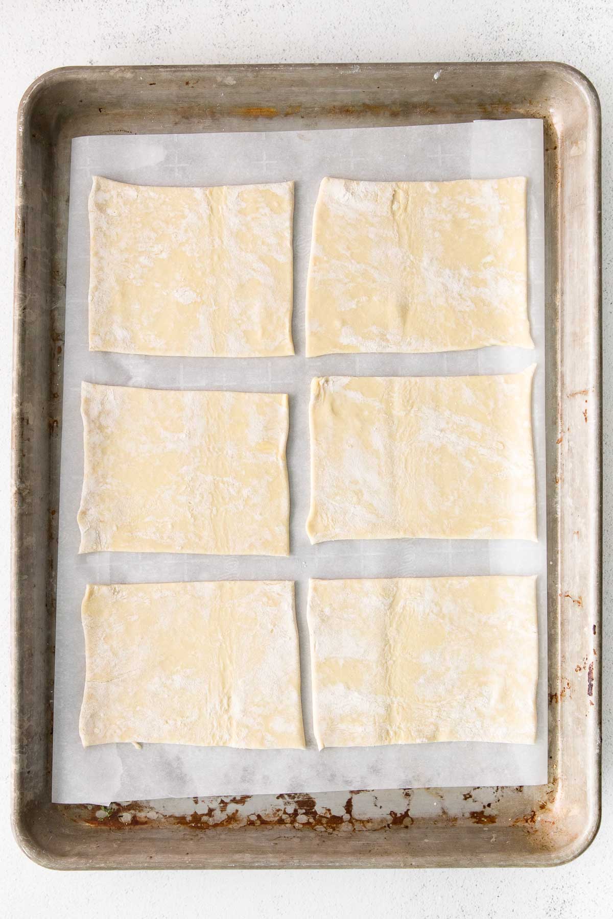 silver tray with six squares of puff pastry dough