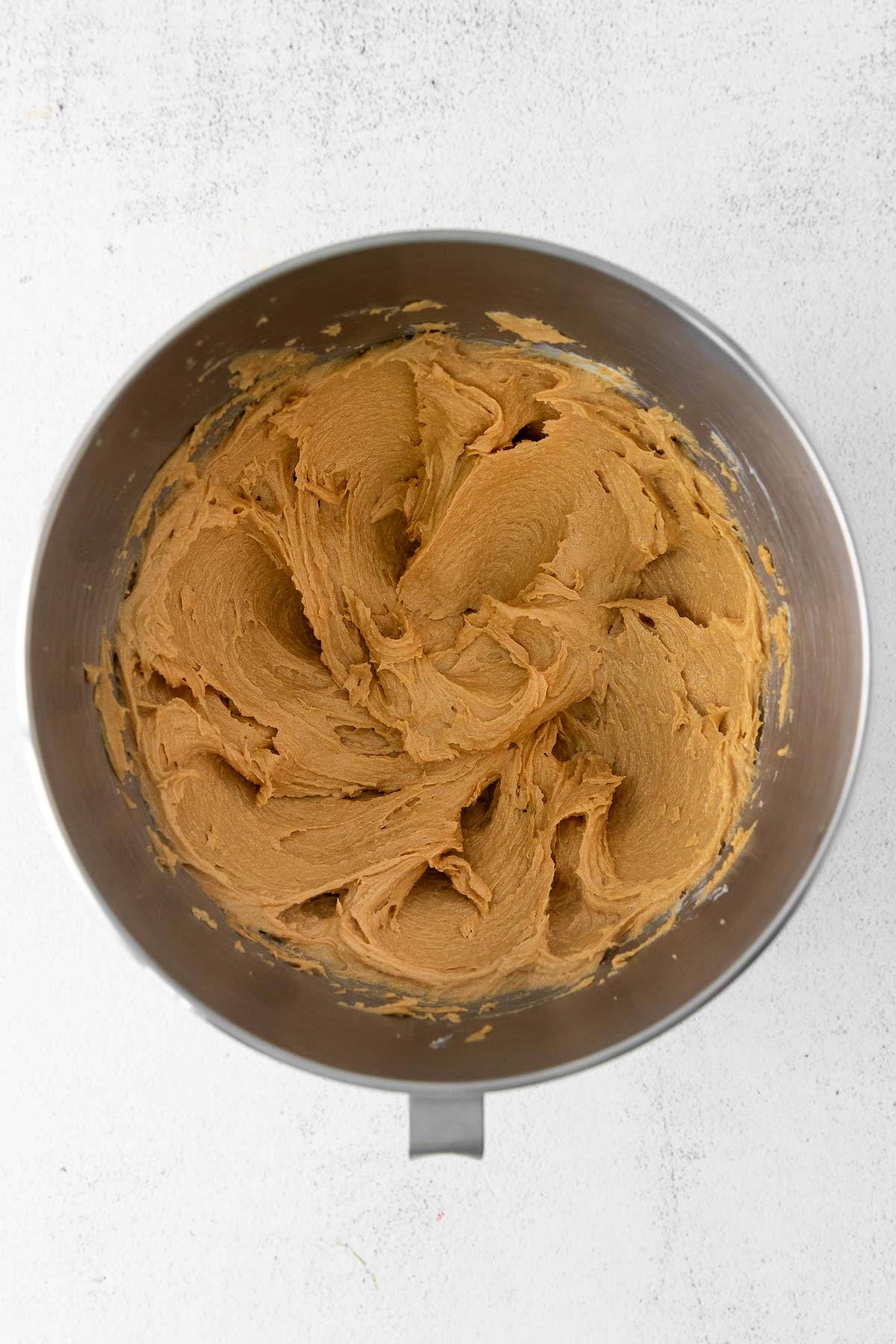 silver mixing bowl with peanut butter cookie batter