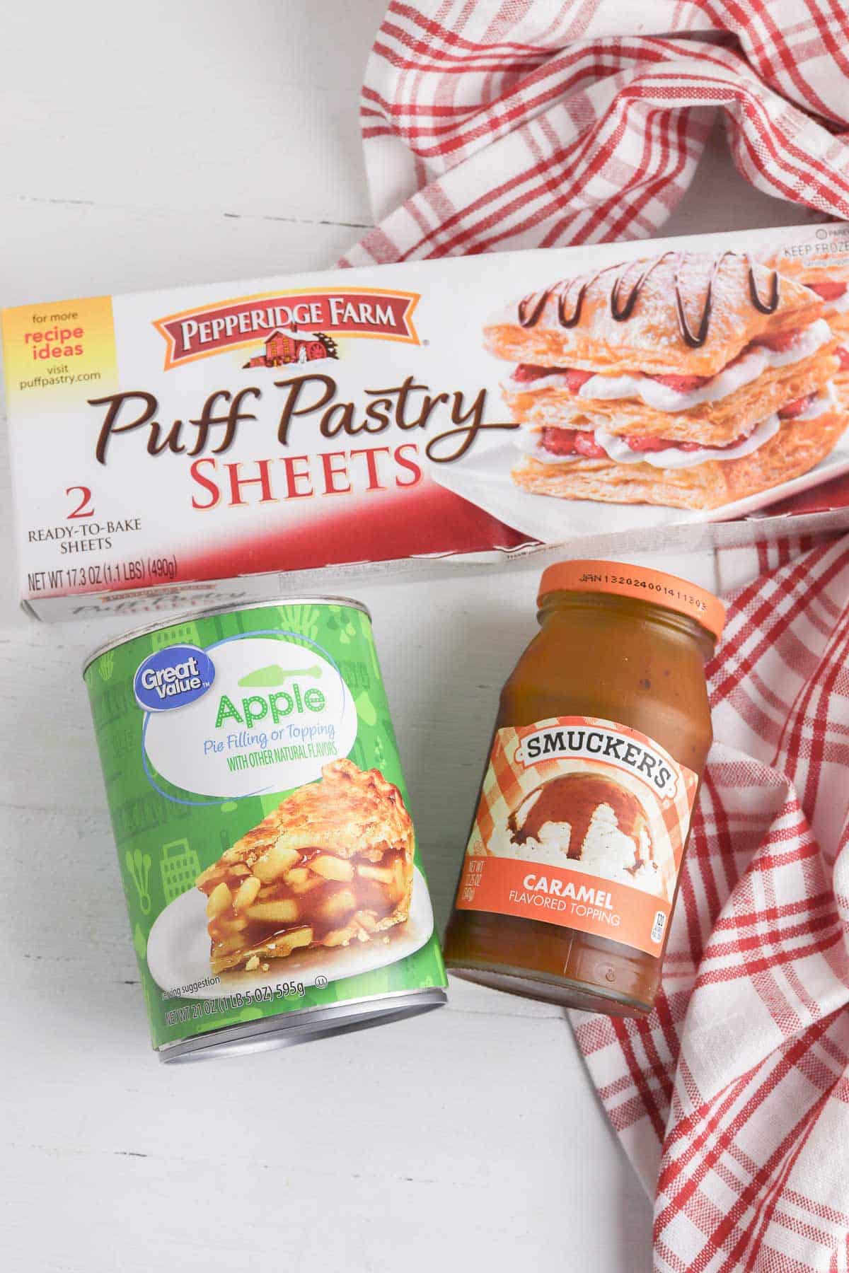 box of puff pastry sheets, can of apple pie filling and a jar of caramel sauce.