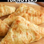 three apple turnovers on a wood cutting board with text overlay the reads apple puff pastry turnovers