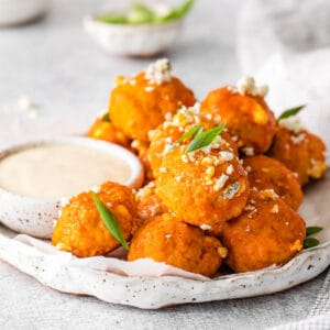 buffalo chicken meatballs topped with blue cheese on a serving plate