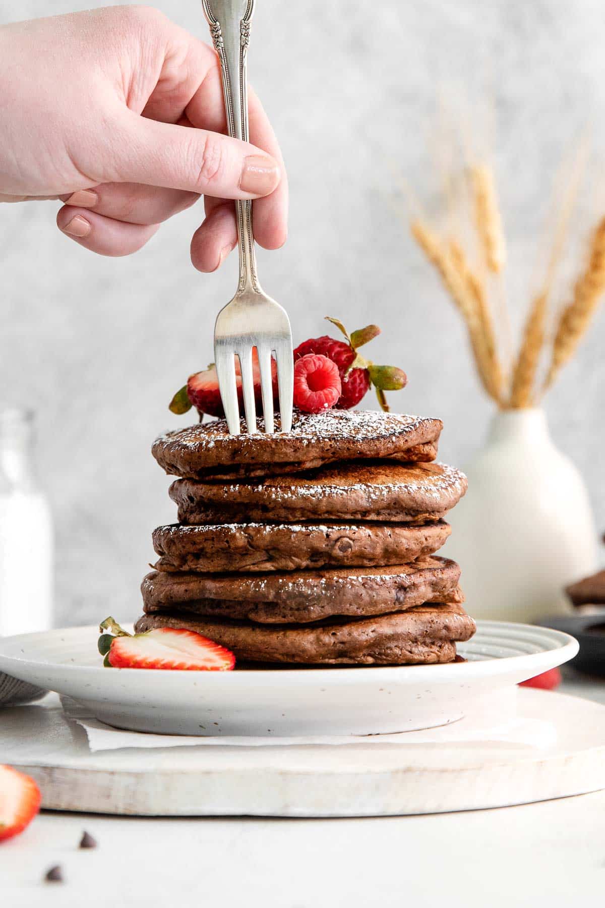 a fork sticking in a stack of chocolate pancakes