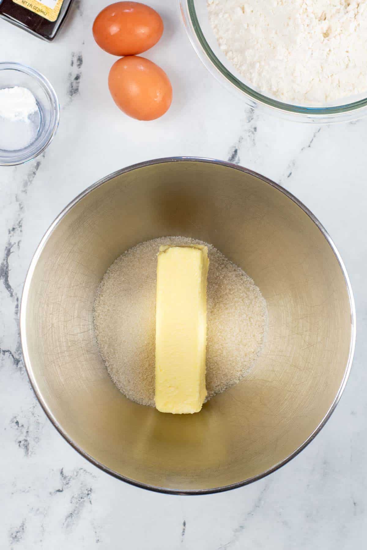 silver mixing bowl with stick of butter and sugar