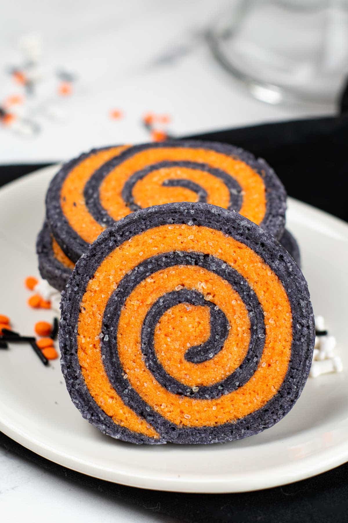 black and orange pinwheel cookie on a white plate.