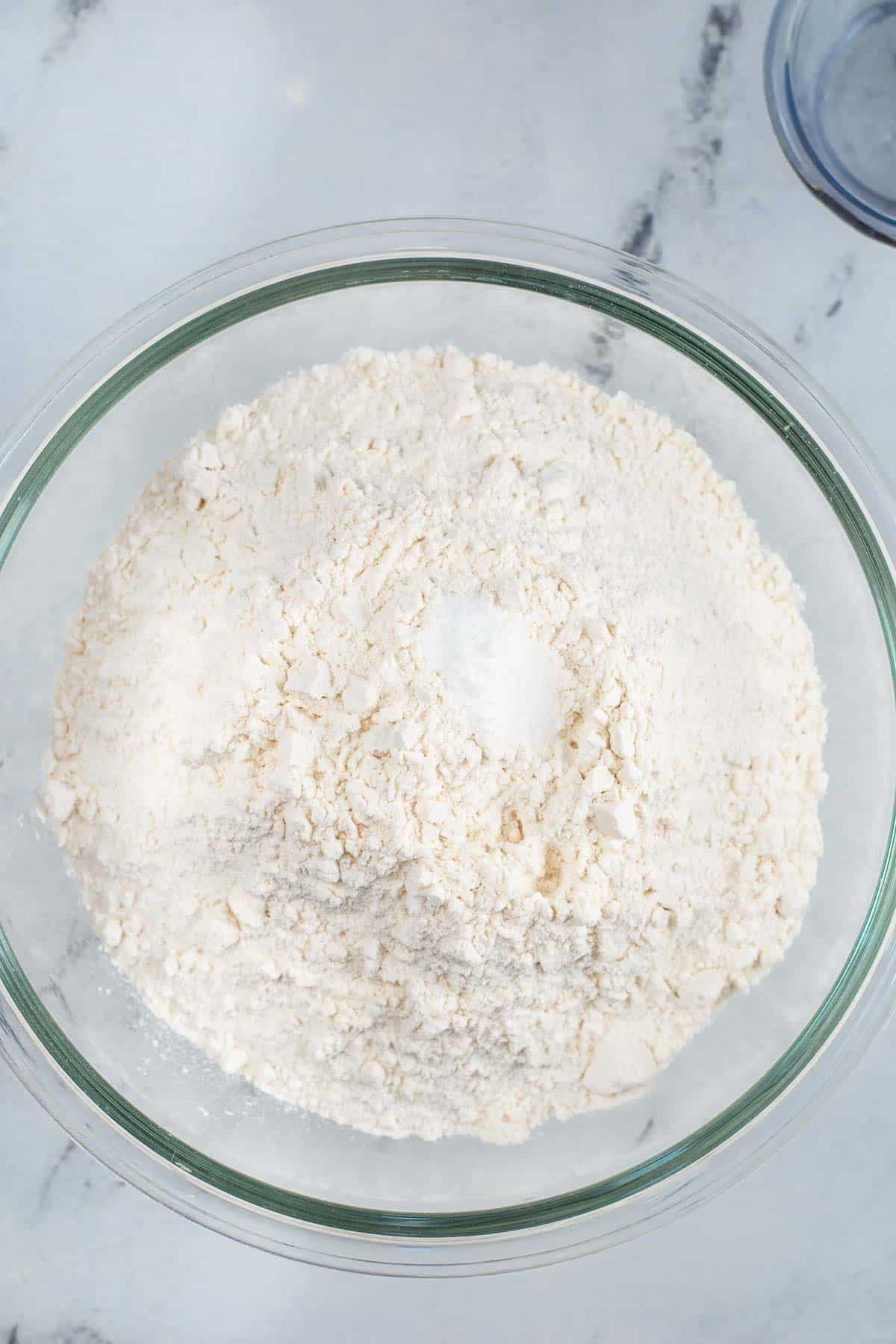 glass mixing bowl with flour and baking powder