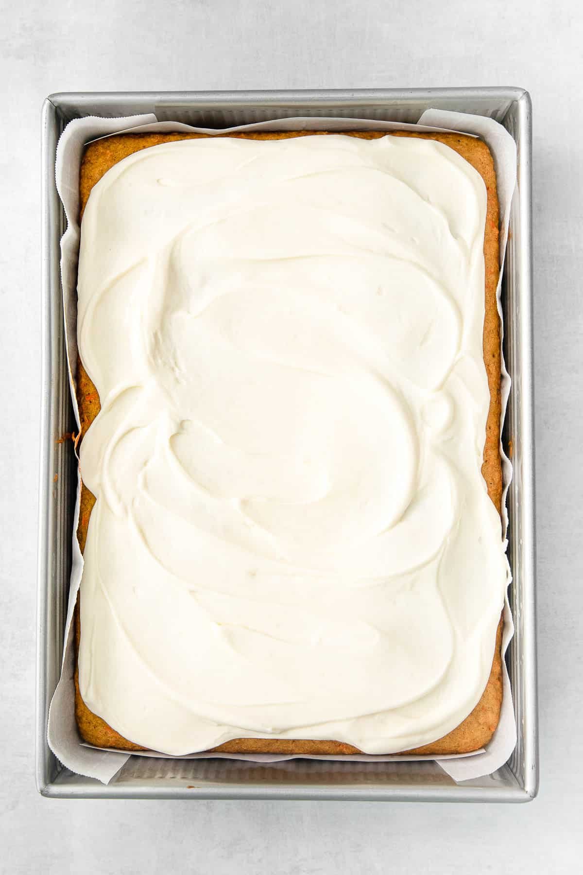 sheet pan carrot cake topped with cream cheese frosting.
