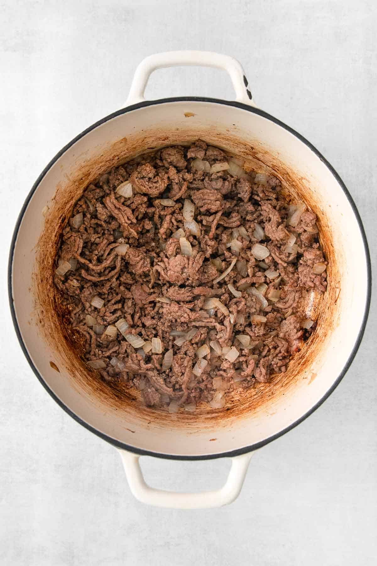white pot with ground beef and onions being browned.