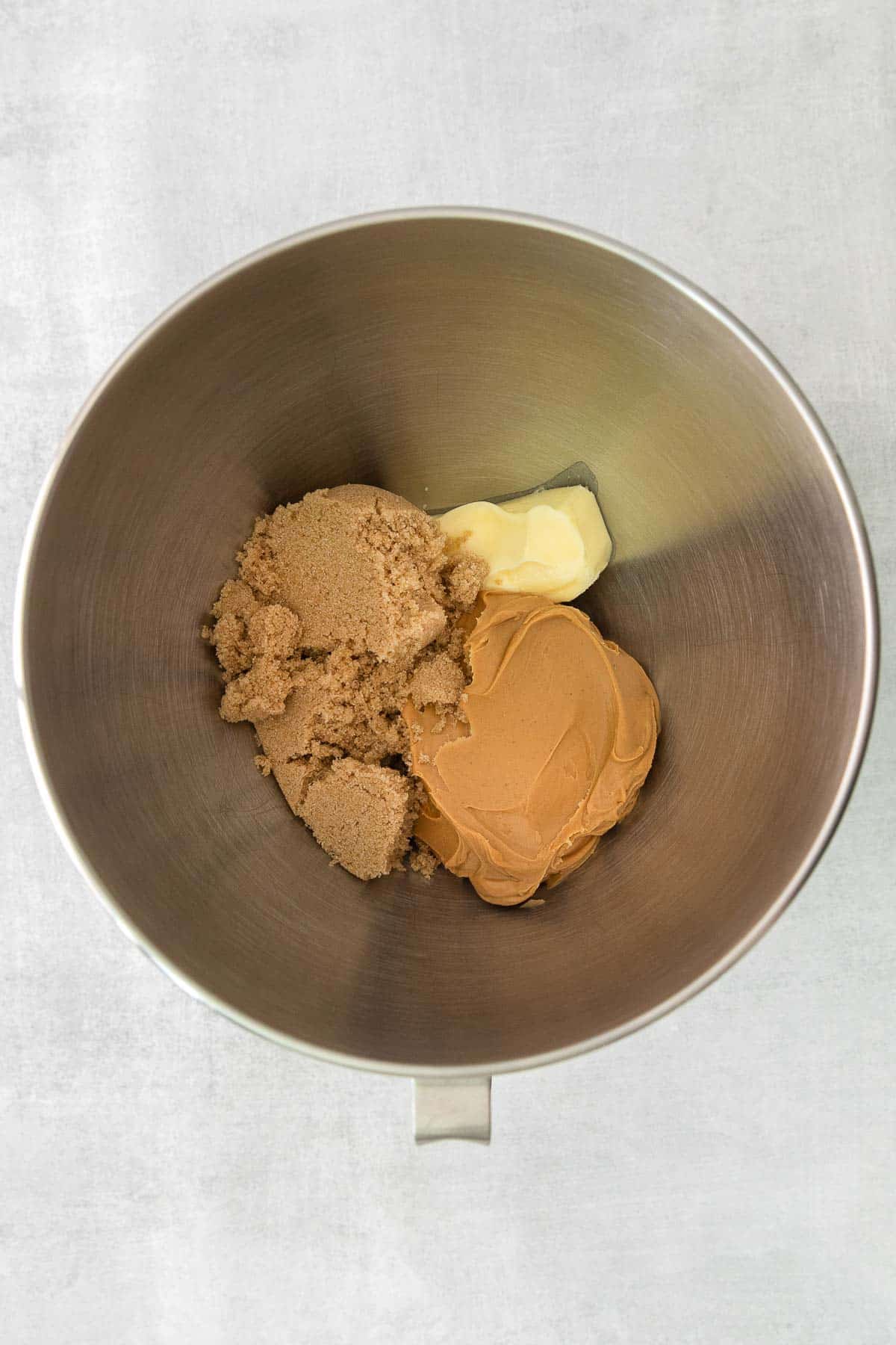 silver mixing bowl with brown sugar, butter and peanut butter.