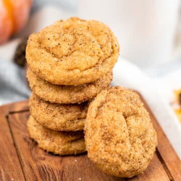 stack of pumpkin snickerdoodle cookies on a wood cutting board