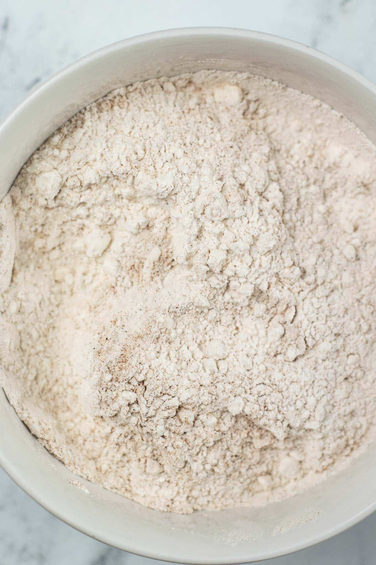 white mixing bowl with flour and cinnamon mixture.