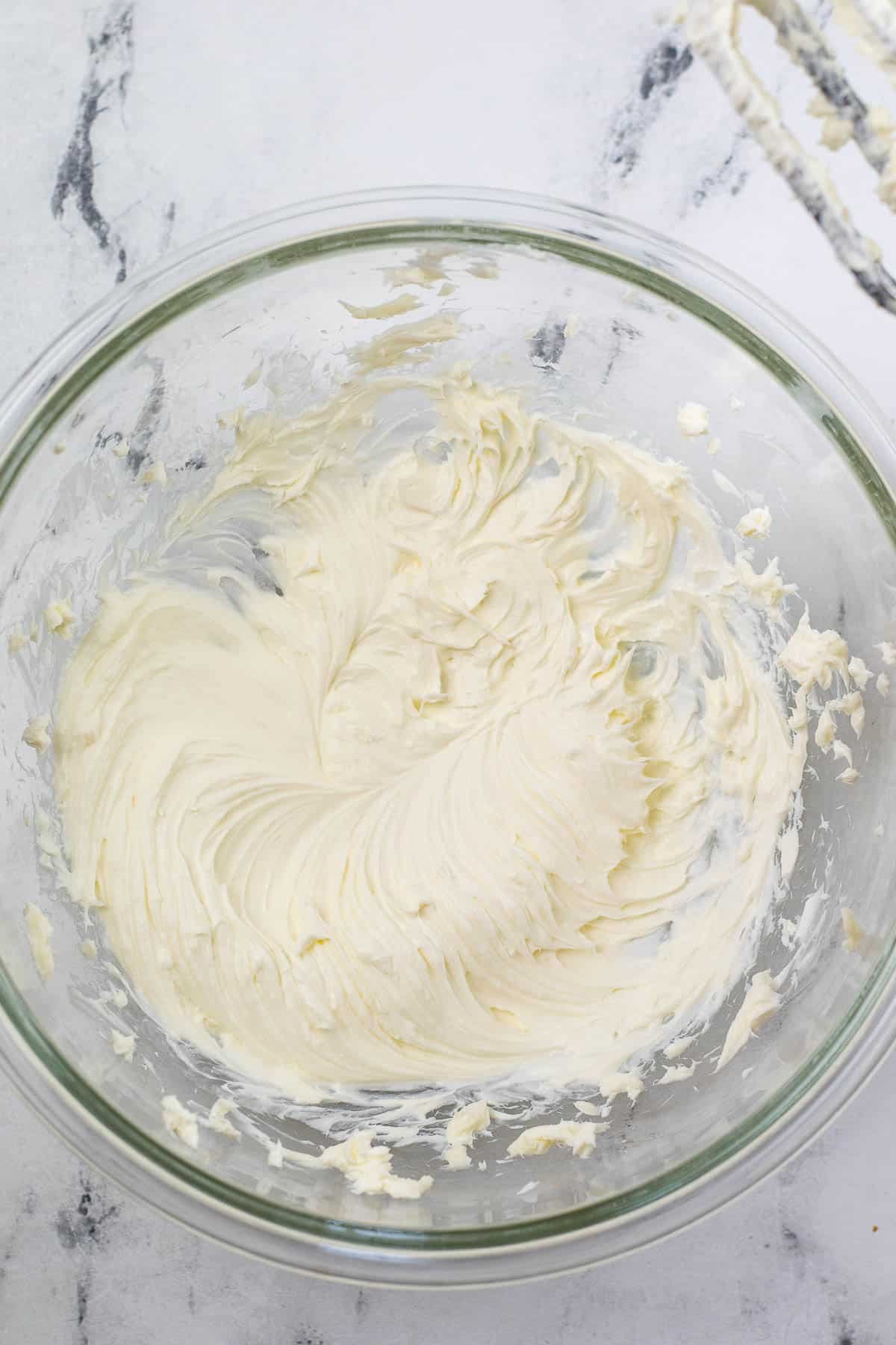 butter and cream cheese creamed together in a big glass bowl.