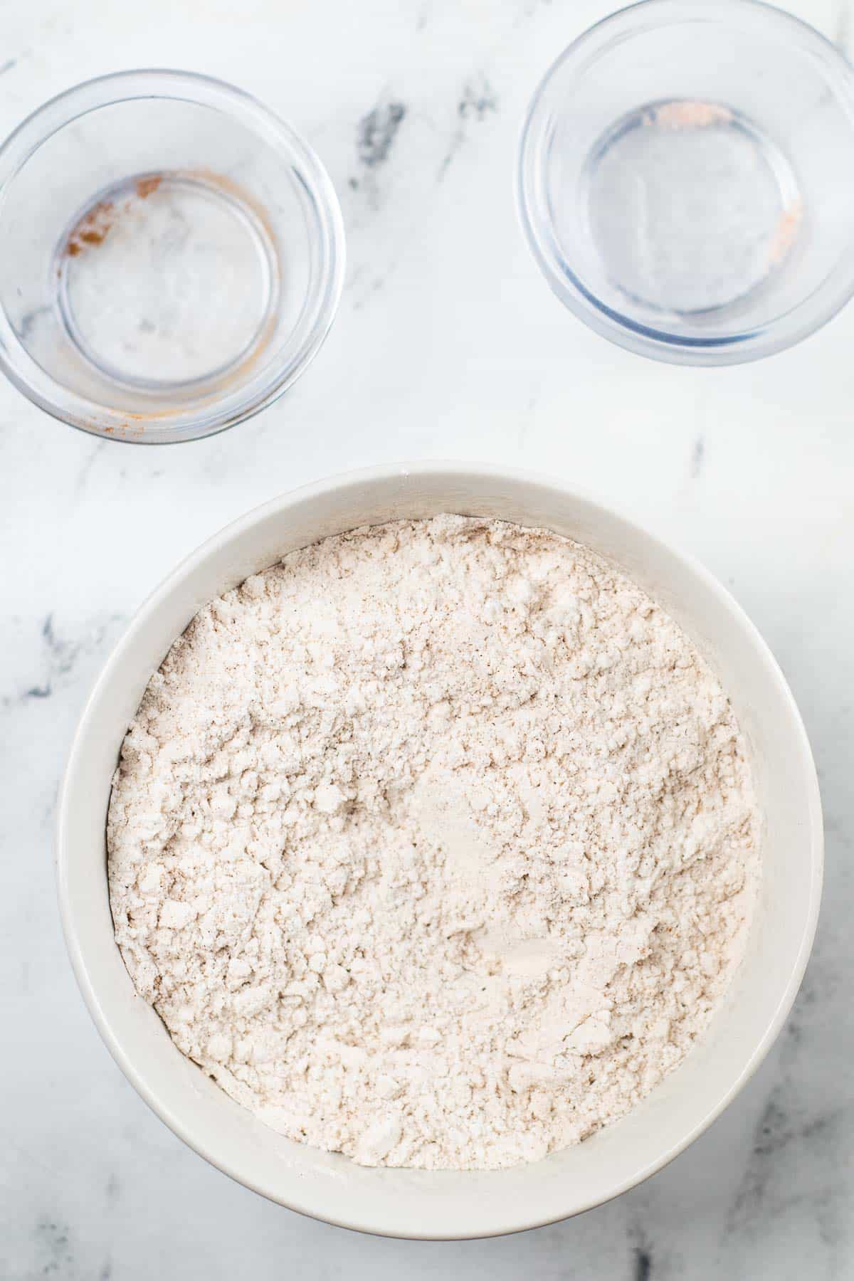 white mixing bowl with flour and cinnamon mixed together.