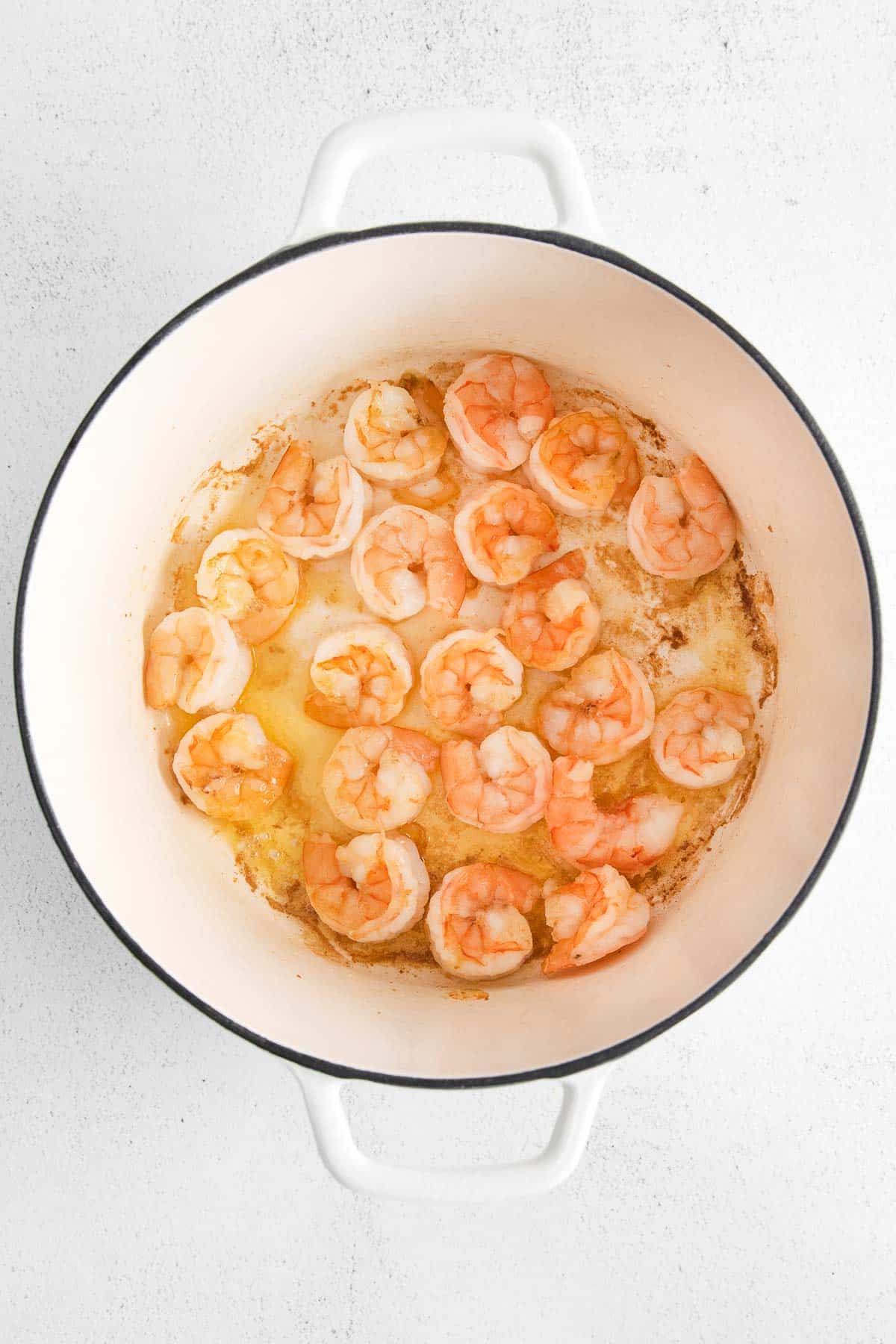 white pot with cooked shrimp covering the bottom
