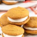 four mini pumpkin whoopie pie with cream cheese frosting filling on a white plate.