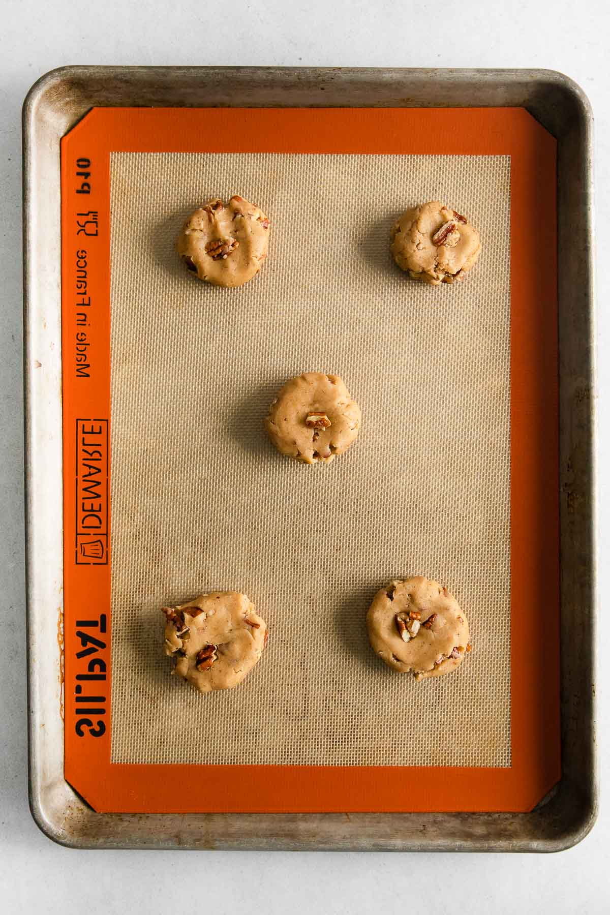 five raw cookie dough balls with chopped pecans
