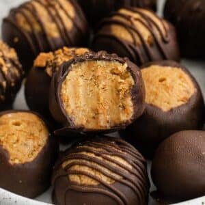 closeup of a stack of chocolate covered butterfinger balls with a bite taken of one