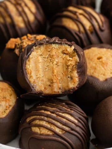 closeup of a stack of chocolate covered butterfinger balls with a bite taken of one