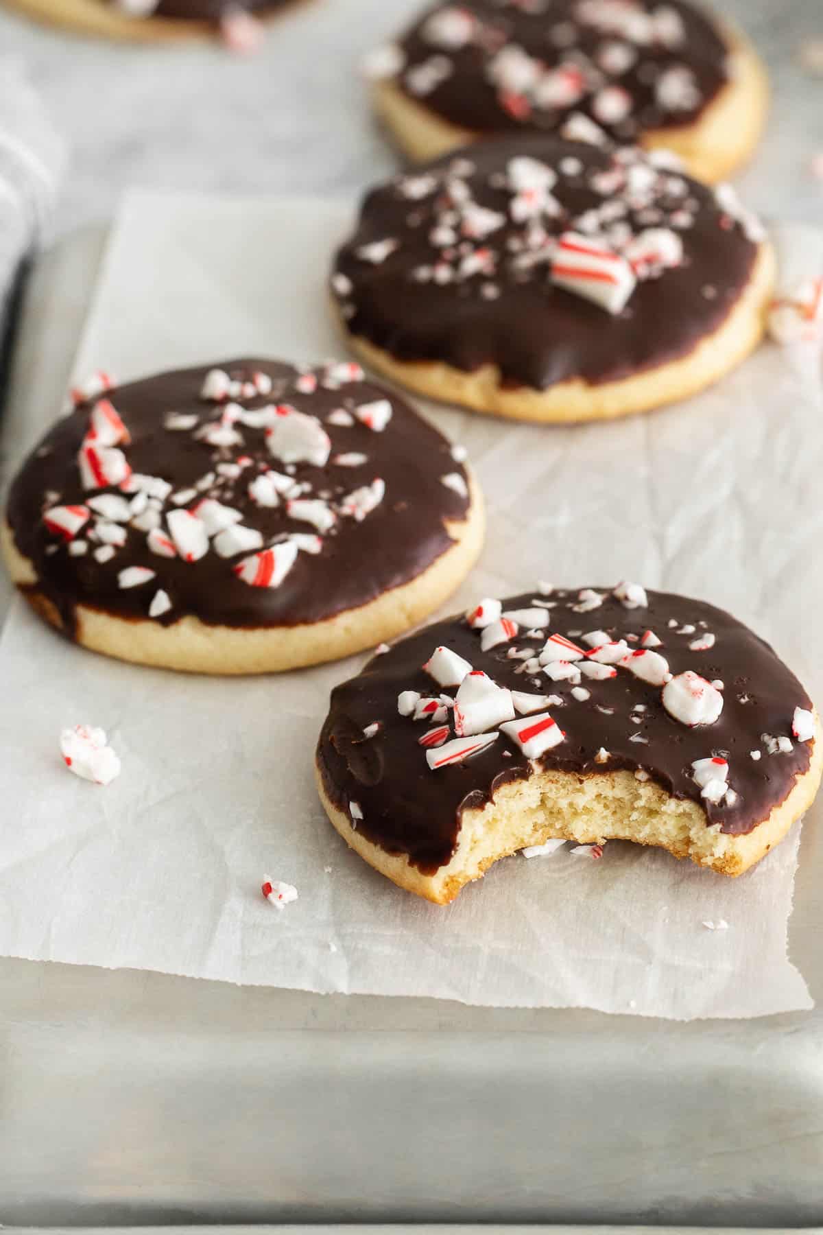 four chocolate covered cookies with peppermint candy pieces on top.