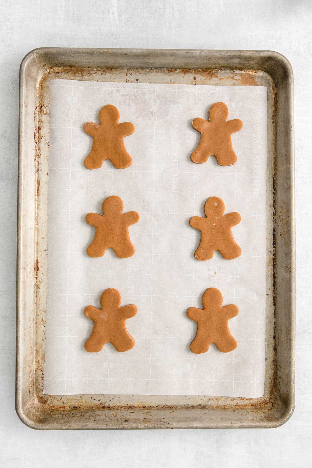 cookie sheet with raw gingerbread men cookies.