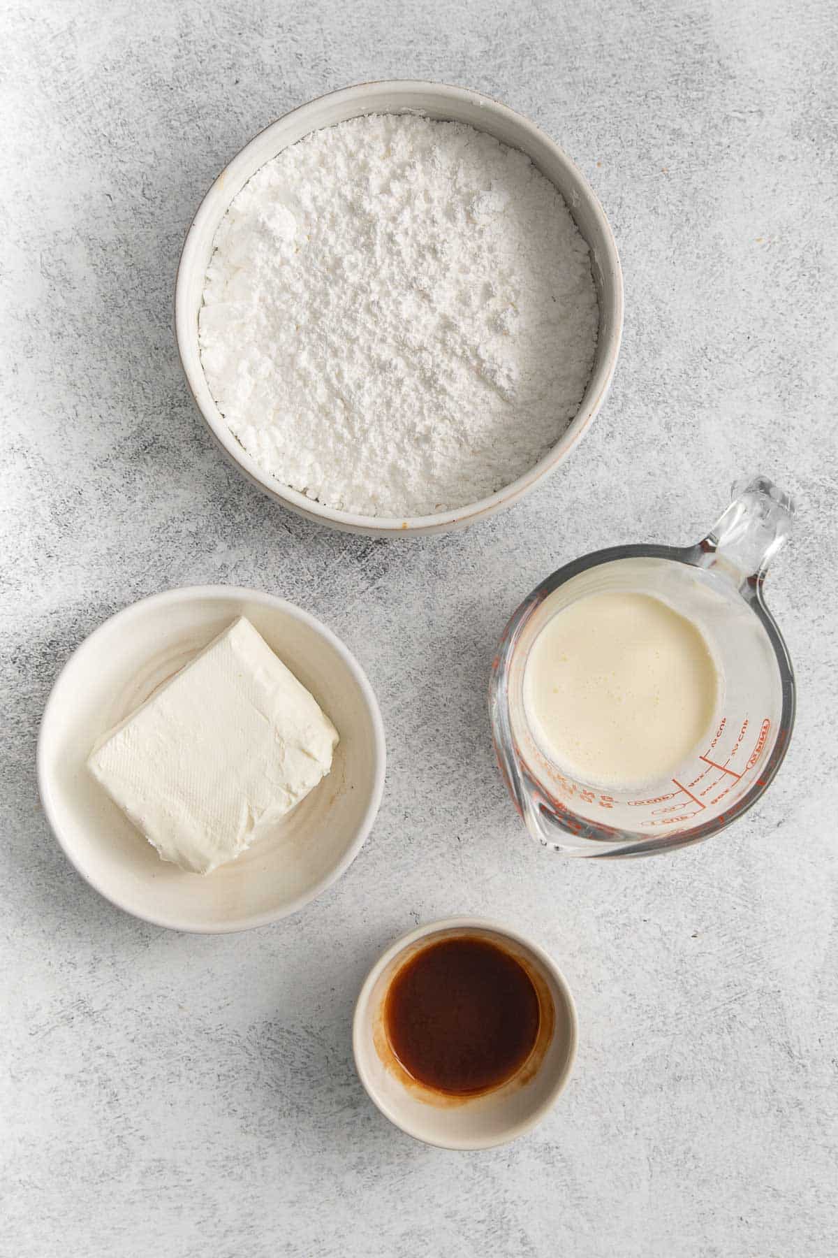 ingredients for cream cheese icing - powdered sugar, cream cheese, milk and vanilla extract.