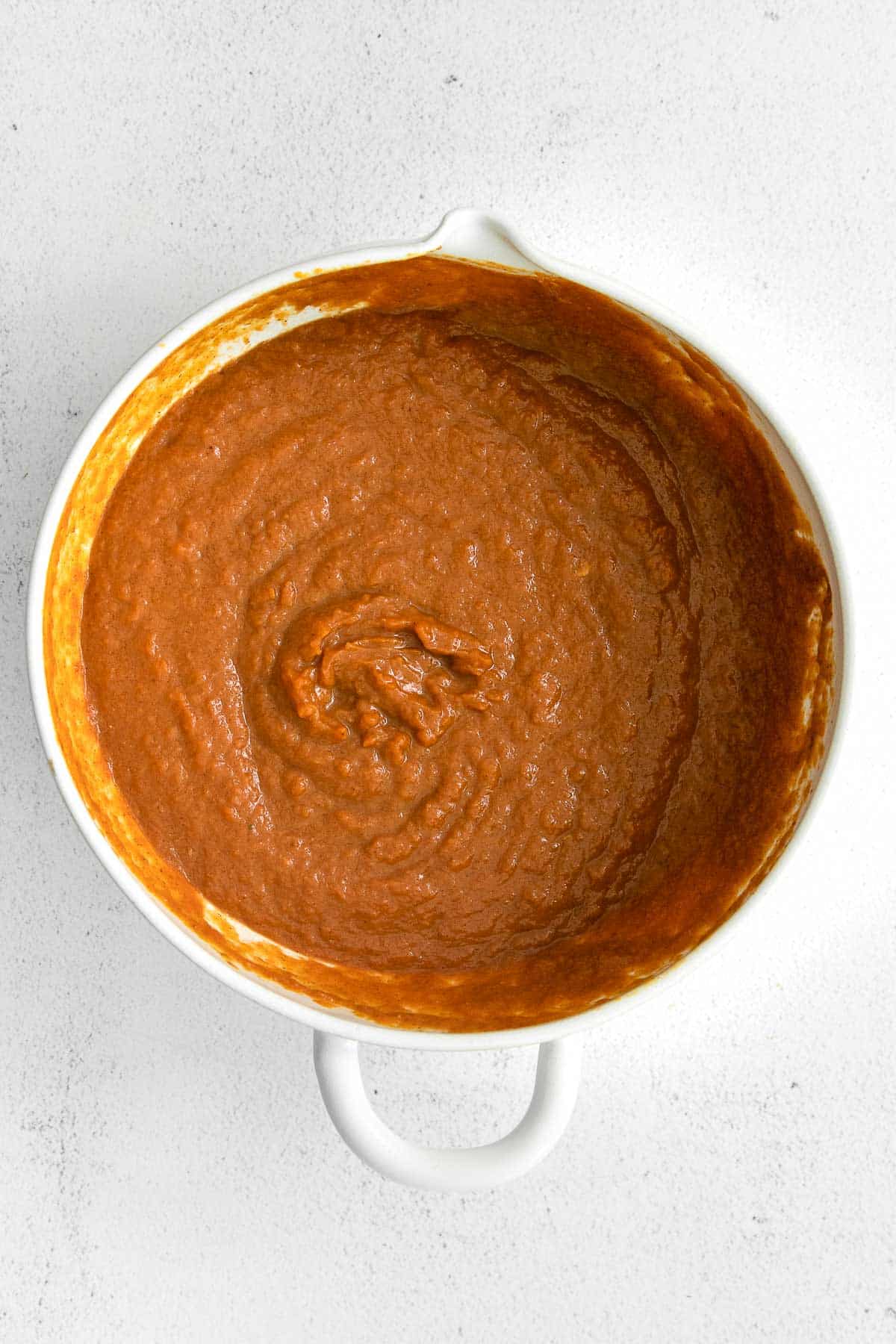 pumpkin pie mixture in a white mixing bowl.